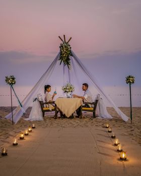 Romantic dinner on the beach, honeymoon dinner on the beach during sunset Thailand, valentine setting Asia