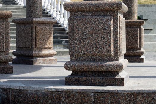 Large brown marble columns close-up on the background of the stairs in vintage style. Urban architecture. Tourism concept.