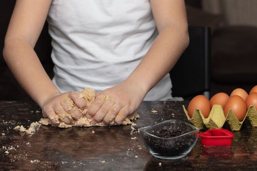 Kids baking cookies in house kitchen . Close-up child`s hands preparing cookies using cookie.