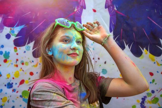 Young people, teenagers and adults celebrate the Holi event in Ukraine in Chernivtsi on March 8 in 2022. They have fun and throw paint at each other. High quality photo