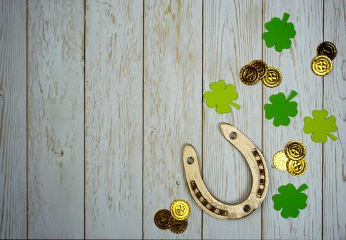 Items for St. Patrick's Day are laid out on a wooden background. Gifts for the celebration of St. Patrick. The horseshoe is in a box with fresh hay.