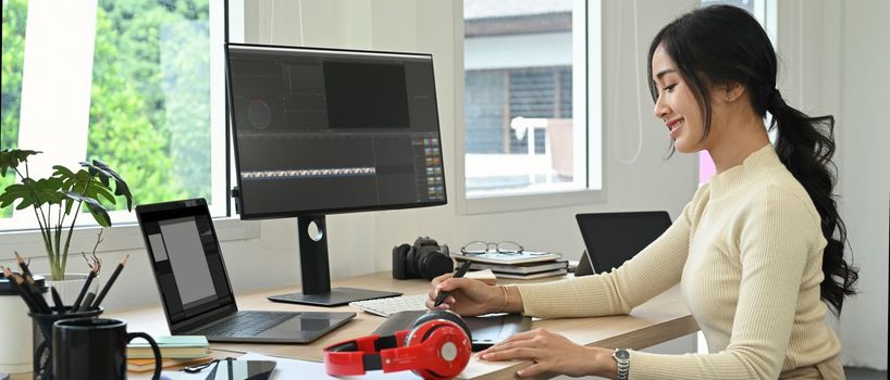 Image of female video editor working with footage and post production montage in creative office studio.