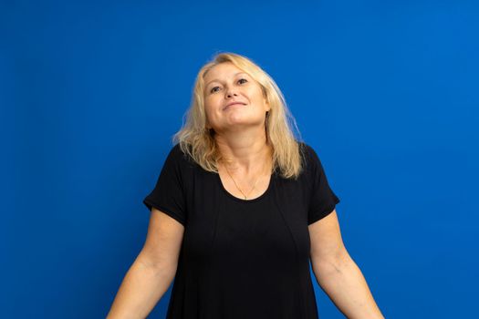 Portrait photo of cute attractive woman shrugging confused uncertain choice isolated on blue toned background