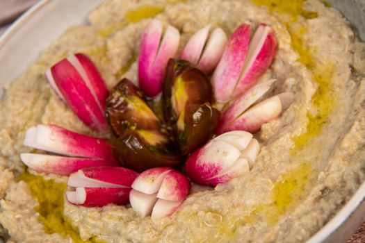 Eggplant caviar with homemade and radish and tomatoes on wooden background. High quality photo