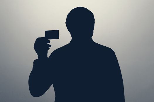 the male silhouette shows a bank credit card. purchasing capacity. fraud concept