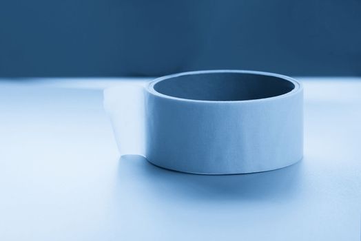 Round roll of white duct tape, adhesive tape on a surface