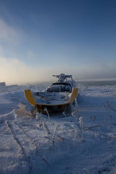 Old snowmobile sitting on a snow covered landscape, near Churchill, Manitoba, Canada