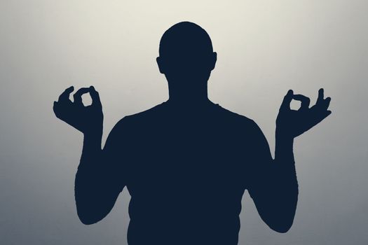 Unknown male person silhouette in studio meditating. Peace in heart concept