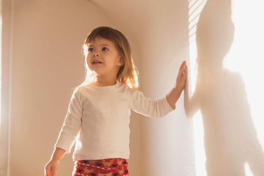 charming beautiful girl plays with her shadow.