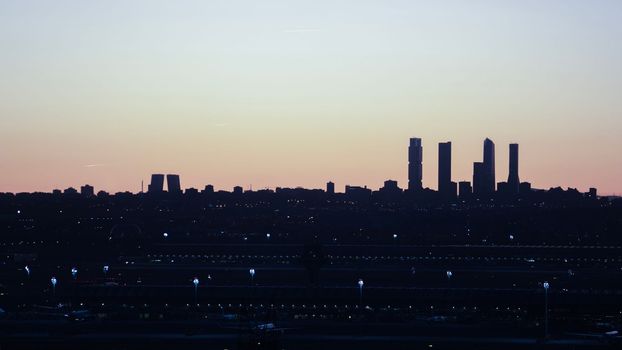 Silhouette of Madrid skyline with business towers after sunset. Blue coloured sky. Winter and cold concept with copy space
