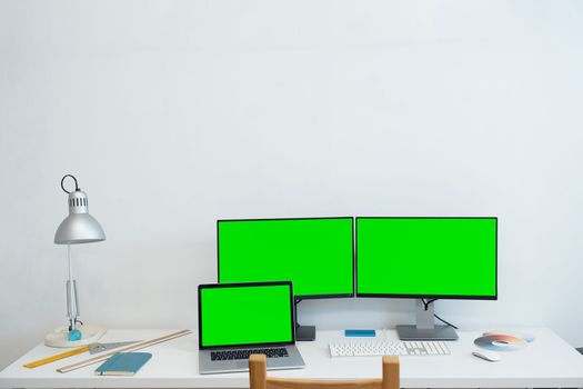 Green screen monitor stands on the office desk - Personal compute mock-up. High quality photo