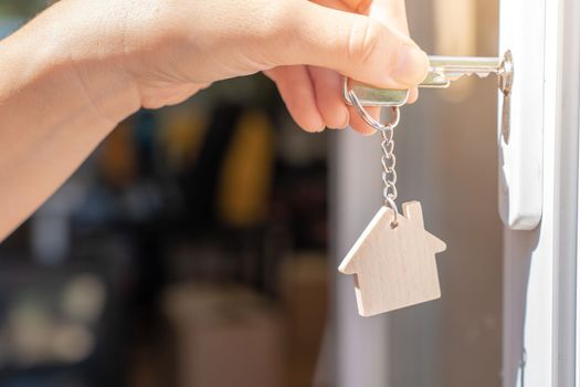 Opening door to a new home with key and home shaped keychain - Mortgage, investment, real estate, property and new home concept. High quality photo