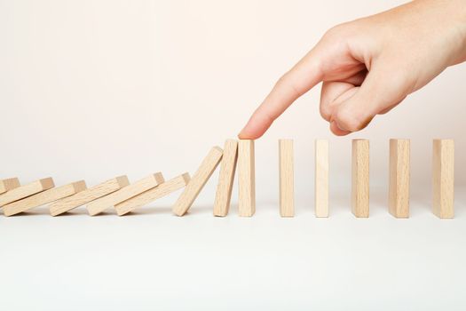 Hand stopping the Domino effect stopped by unique, Business Ideas
