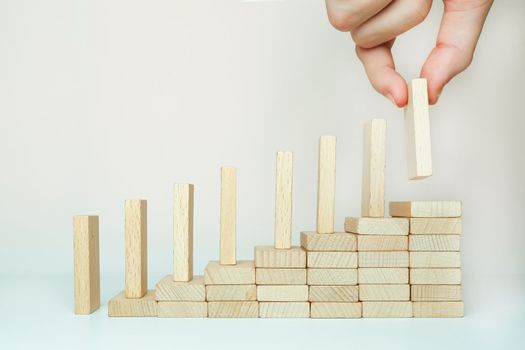 The domino effect is built by climbing the stairs on a wooden staircase lined with steps. One in hand