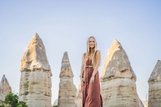 Woman tourist on background of Unique geological formations in Love Valley in Cappadocia, popular travel destination in Turkey.