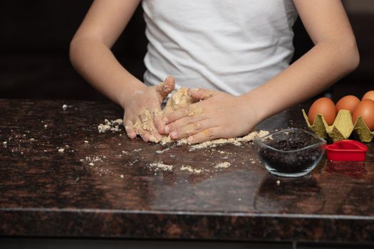 Kids baking cookies in house kitchen . Close-up child`s hands preparing cookies using cookie.