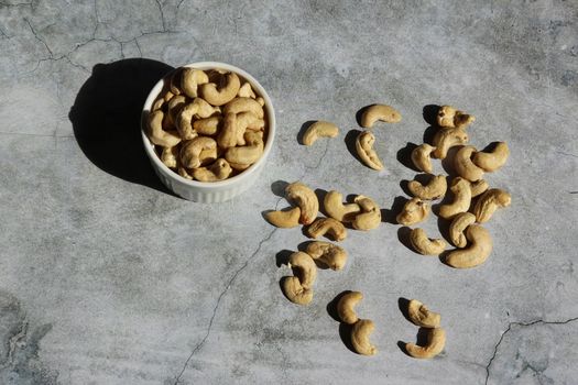 Cashew nuts on the grey cement background. Top view.