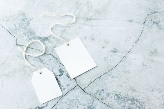 Rectangle tag mockup, square tag mockup with white cord, close up. Various price cardboard labels on concrete background. Blank empty paper product tags, sale and black friday concept