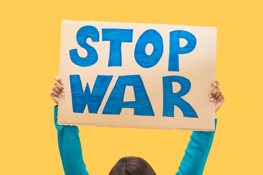Closeup stop war sign against yellow background. Isolated woman protest slogan. High quality photo