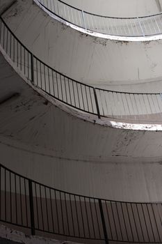 old and dirty car parking area with spiral stairs