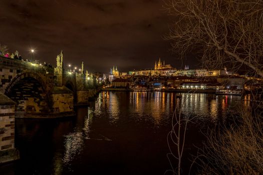 Night view of Charles Bridge and Mala Strana in Prague during winter.