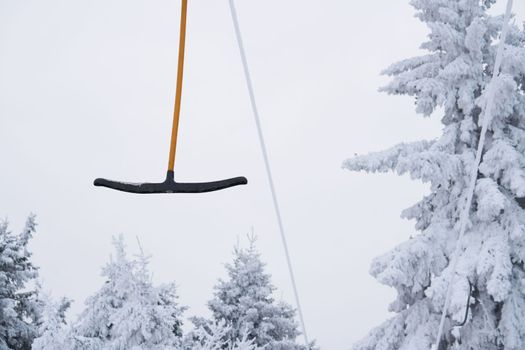 part of a ski lift against the backdrop of a magnificent winter landscape on the Wasserkuppe mountain in Rhen, Hesse, Germany. magical tall and large pines and snowy firs covered with snow and ice. The horizon creates an illusion and merges with the cloudy sky and fog, which covers all the space visible in the distance. High quality photo