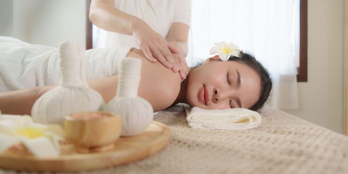 Young woman doing relaxing massage in spa salon. Female being massaged by a masseur. Spa and medicine concept.