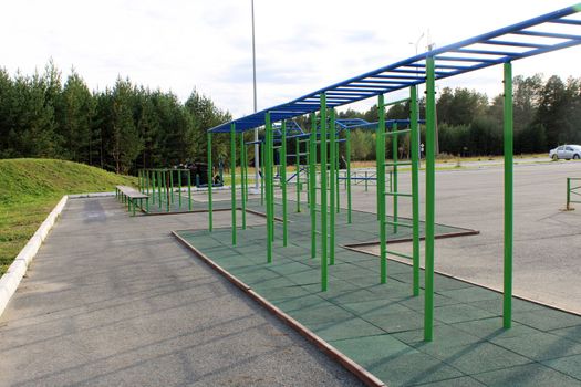 Sports outdoor playground with exercise equipment outside the city against the backdrop of the forest. The concept of a healthy lifestyle