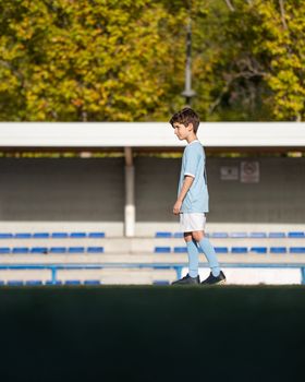 Portrait of Caucasian child boy entering a soccer stadium, dreaming of becoming professional player, soccer star. Copy space.