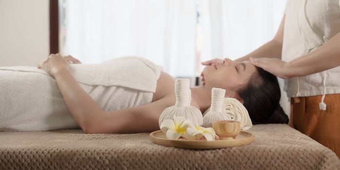 Young woman doing relaxing massage in spa salon. Female being massaged by a masseur. Spa and medicine concept.