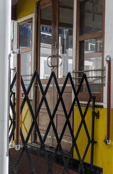 Entrance to the ancient yellow Portuguese tram with wooden door background