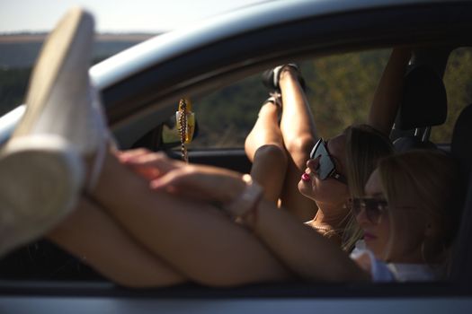 skinny girls eat in the car away from the bustle of the city, best friends are free and enjoy the journey. High quality photo