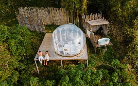 A couple of men and women staying at a luxury glamping tent in the mountains