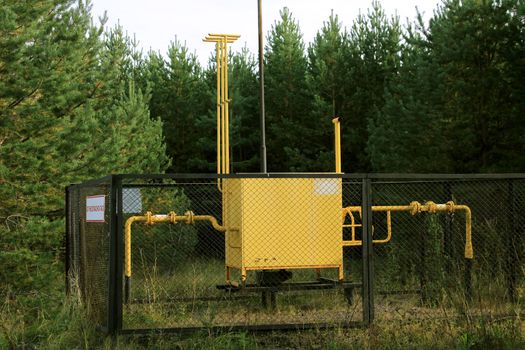 Gas distribution point, fenced with a grid in the forest. The concept of the energy crisis, lack of fuel. Translation flammable, gas.