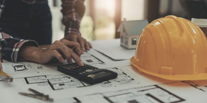 Concept architects, engineer holding pen pointing equipment architects On the desk with a blueprint in the office