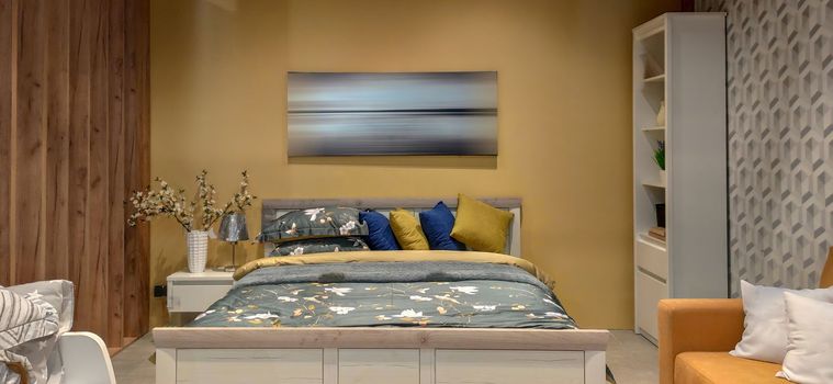 Interior photography, large bedroom with large bed. bedroom interior with bedding sheet yellow tone and picture on the wall sweet home style, wooden headboard. download image