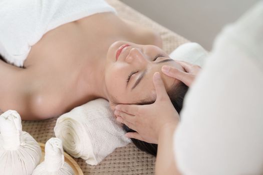 Young woman doing relaxing massage in spa salon. Female being massaged by a masseur. Spa and medicine concept.