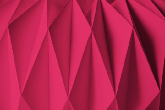 Macro Viva Magenta image of paper folded in geometric shapes, three-dimensional effect, abstract background. Out of focus. Trendy color 2023 Viva Magenta. High quality photo