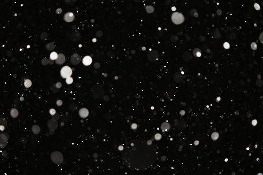 Snowfall at night. White on black. Winter snow background