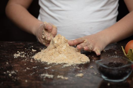 Kids baking cookies in house kitchen . Close-up child`s hands preparing cookies using cookie.