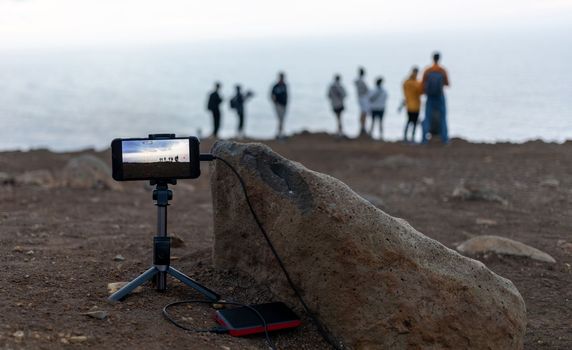 smartphone on tripod shooting a group of people at sightseeing. High quality photo