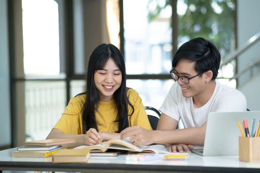 Young woman and man studying for a test or an exam. Tutor books with friends. Young students campus helps friend catching up and learning.