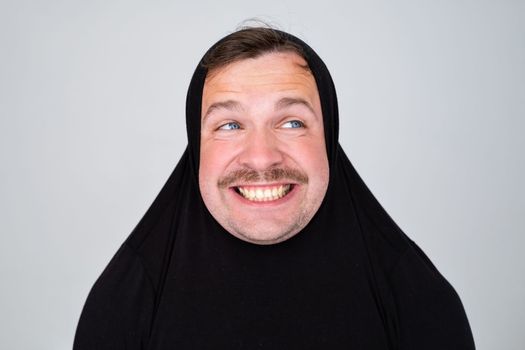 Funny man covering head with sweater smiling cheerful and funny.
