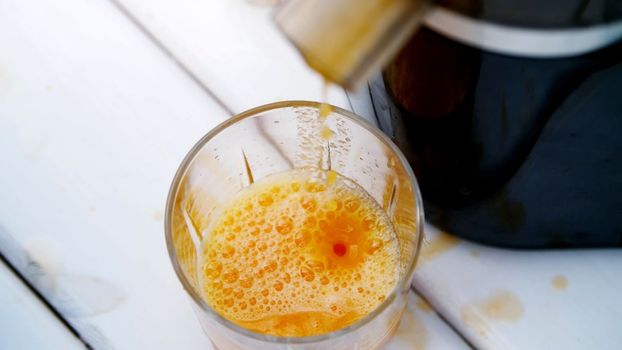 happy beautiful family, mom, dad, four years old son and one-year-old daughter make fresh fruit juice. In summer, in garden. The family spends their leisure time together. High quality photo