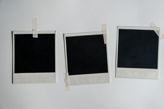 Collection of blank photo frames taped on white wall. Set of photos frame for your picture. Photo frame on a white background. download image