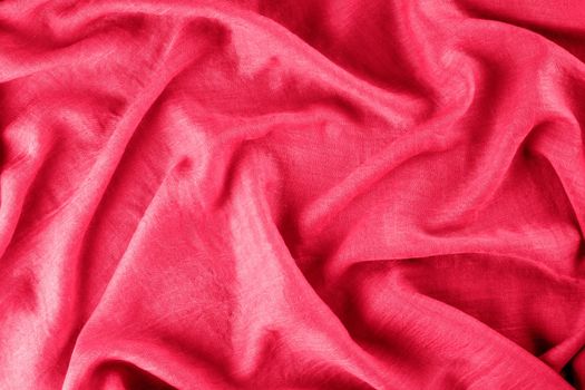 Close-up of draped fabric as background. Viva magenta, color of year 2022 Selective focus.