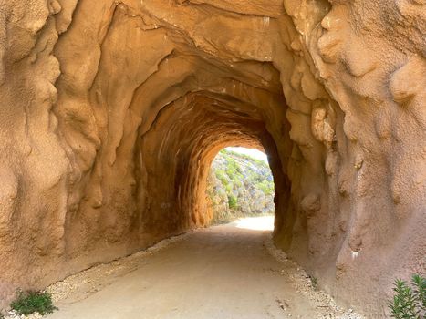 Beautiful trekking.and mountain cycling path through a tunnel. Old railway that transported coal from mines to the Thermoelectric Power Station. National park near Porto do Mos, Portugal.