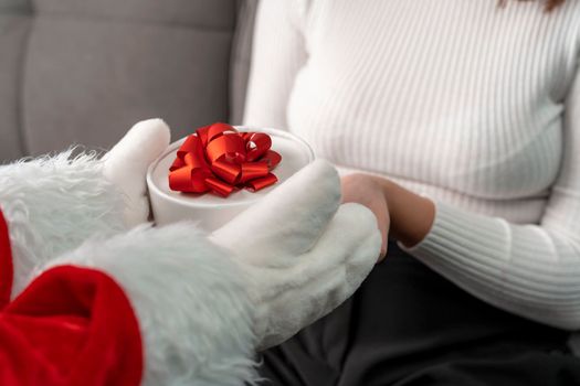 Santa gives a Christmas gift to a girl. Santa's hands are holding a beautiful gift box. Christmas time. Merry Christmas and Happy New Year.