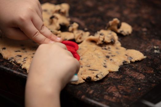 Kids baking cookies in house kitchen . Close-up child`s hands preparing cookies using cookie.