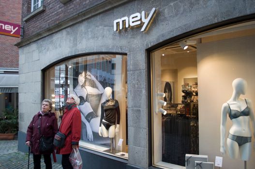 two old women stand in front of a display case with underwear and look in the opposite direction completely uninterested in beautiful clothes, Aachen, Germany, December 5, 2015 High quality photo